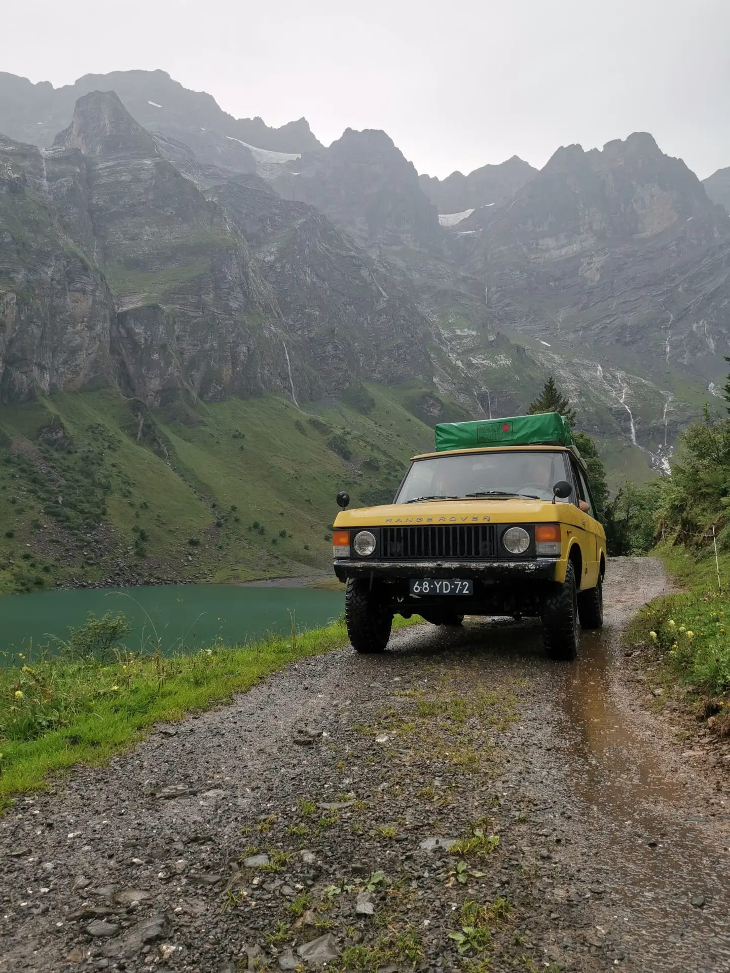 A Range Rover Suffix C driving on a mountain path, the car has an oldtimers number plate showing 68-YD-72