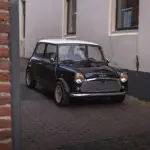 A black Mini City driving out of the alley