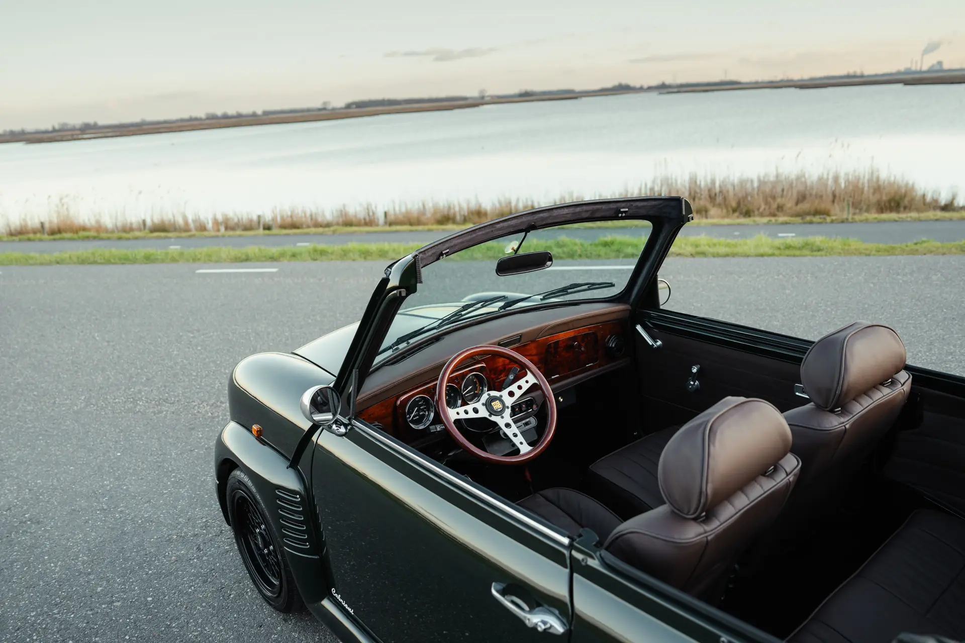Mini classic custom interior done by brooks motors. wooden dashboard with wooden momo steering wheel and brown leather seats in a porsche brewster green mini