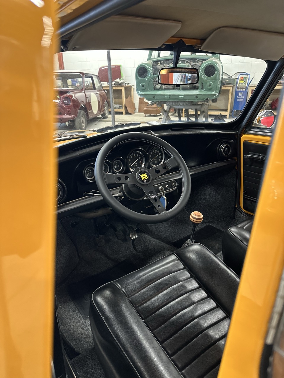innocenti mini cooper 998c mk3 interior in black photographed in the brooks workshop with momo steering wheel and momo steering knob